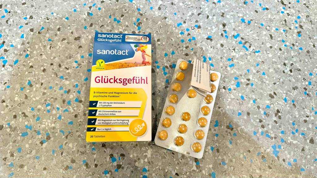 Die Verpackung und die Plissee-Verpackung der getesteten natürlichen Stimmungsaufheller liegen nebeneinander auf einem Boden.