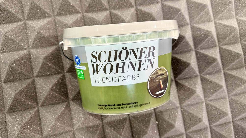 Eine grüne Wandfarbe die getestet wurde, liegt auf einer grauen Schalldämmung.