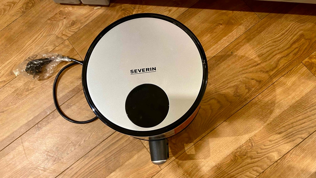 Eine getestete, kleine Heißluftfritteuse von oben auf einer Holzfläche.