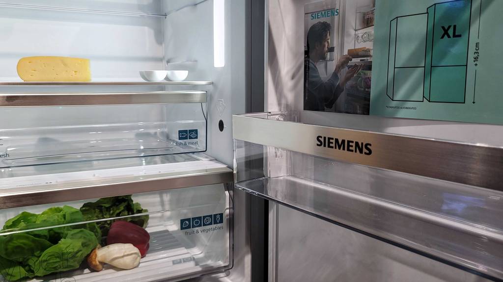 Getestete Einbau-Kühl-Gefrierkombination von Siemens: offene Fronttür, Innenraumansicht mit Einlegeboden und Schubläden.