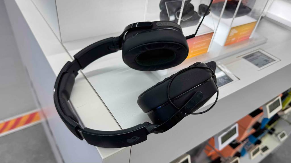 Der schwarze Skullcandy Kopfhörer im Test befindet sich, mit Fokus auf die weiche Ohrmuschel, auf einem Ausstellungstisch im Verkaufsbereich.