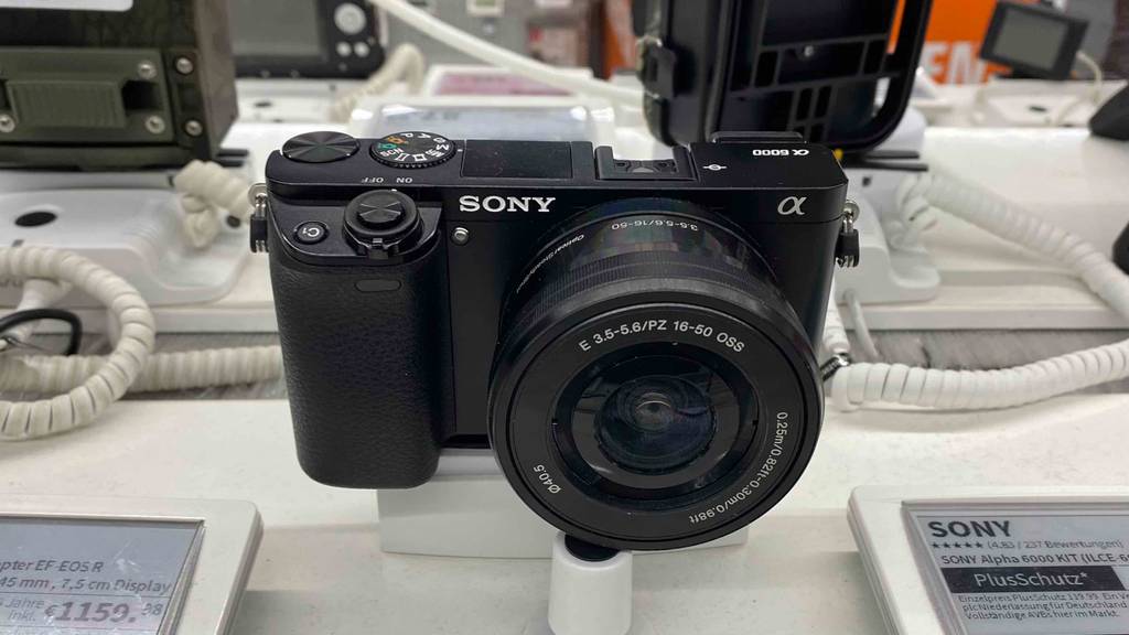 Eine getestete Sony-Kompaktkamera von vorne in einer Austellungsfläche.