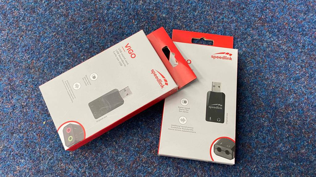 USB-Soundkarte getestet: Zwei Packungen leicht übereinander auf einem blauen Teppich.