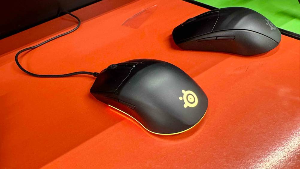 Die beleuchtete SteelSeries-Maus, die getestet wurde ist neben einer abgeschalteten Maus platziert.