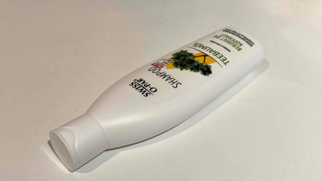 Teebaum-Shampoo getestet: Shampooflasche der Marke Swiss-o-par liegend auf einer weißen Fläche.