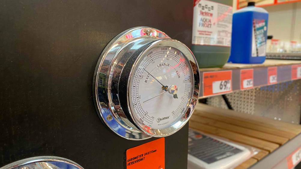 Ein getestetes Barometer an einer Holzwand moniert schräg von der Seite.