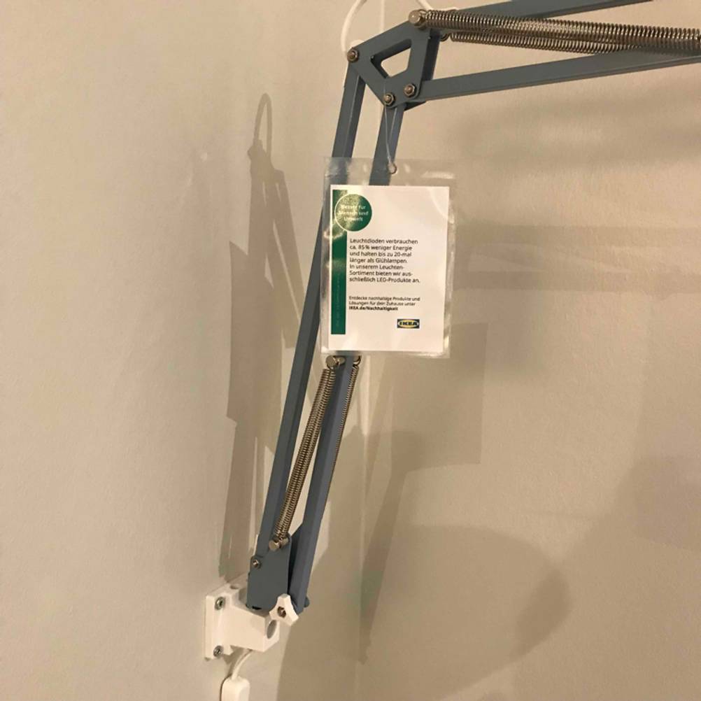 Ein an der Wand moniertes Buchlampen-Gestänge mit Label.