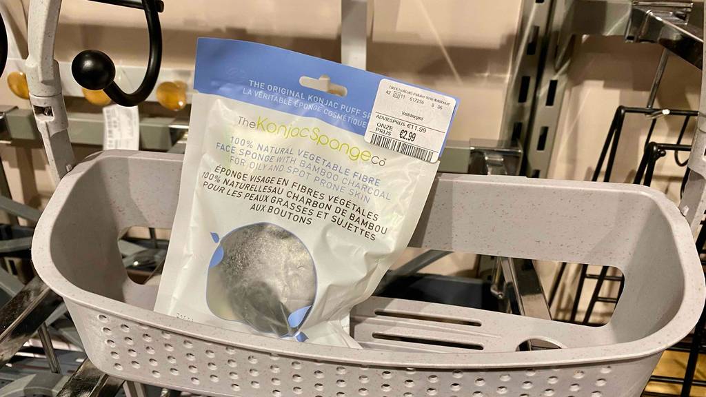 Konjac-Schwamm getestet: schwarzer Konjac-Schwamm in der Verpackung ist in einem Duschregal platziert.