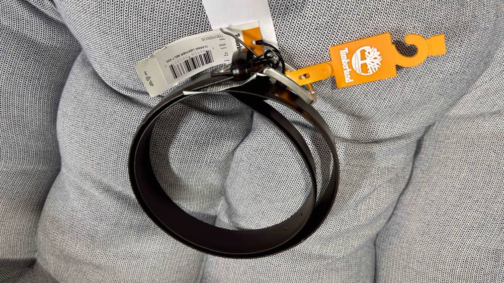 Der getestete Herren-Ledergürtel liegt auf einem grauen Rückenpolster.