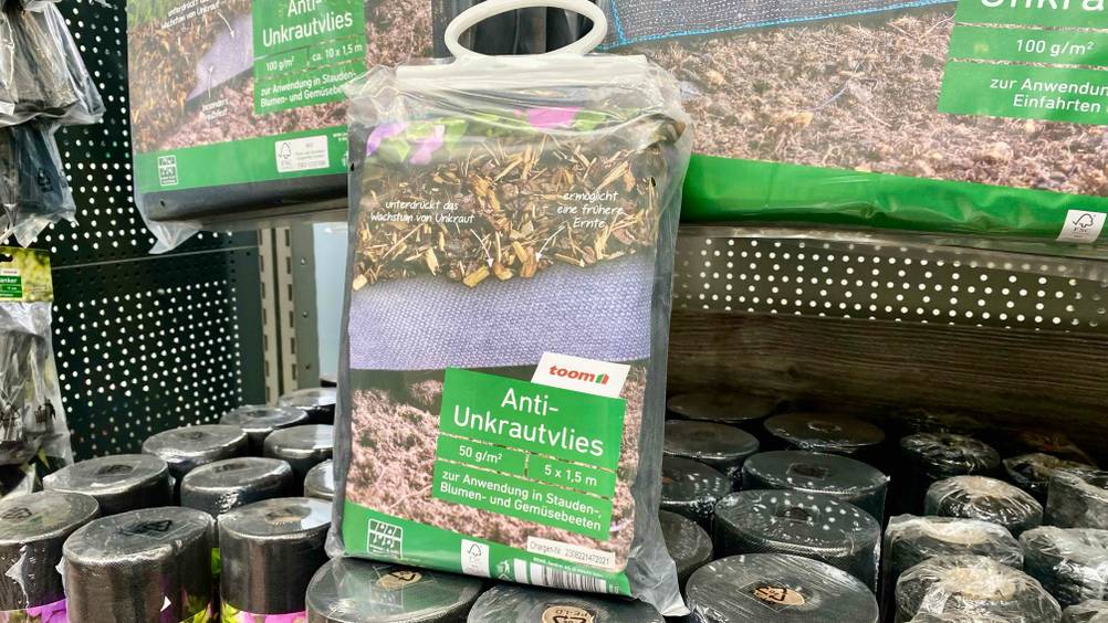 Unkrautvlies im Test: Unkrautvlies in einer Plastikverpackung stehend in einem Geschäft auf anderen Artikeln.