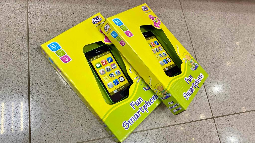 Smartphone-für-Kinder-Test: zwei Verpackungen von Kindersmartphones mit einer Altersangabe von 10 Monaten liegen auf einem Boden.