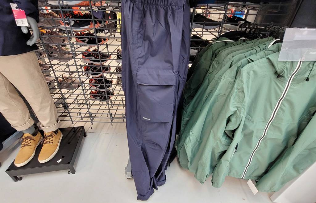 Regenhose-Herren-Test: dunkelblaue Regenhose für Herren hängt in einem Geschäft.