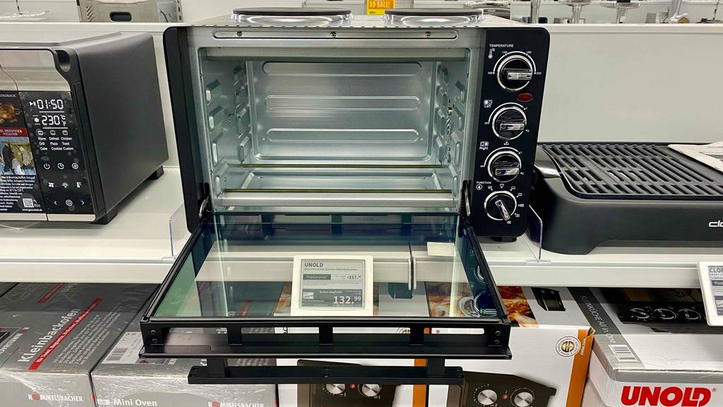 Ein getesteter Minibackofen mit Kochplatten, mit geöffneter Klappe von vorne in einer Ausstellungsfläche.