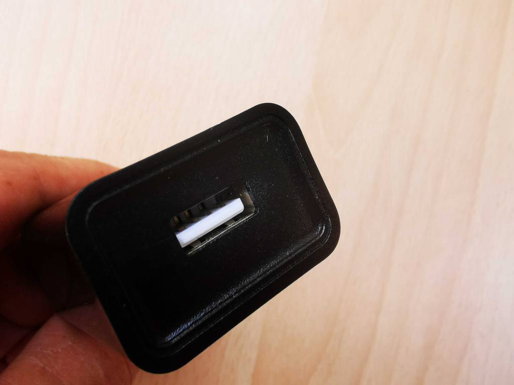 Das getestete USB-Ladegerät in einer Hand, der Fokus liegt auf der USB-Buchse.