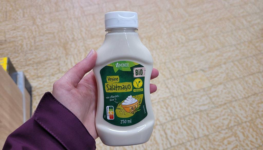 Die getestete vegane Mayonnaise wird in der Hand gehalten.