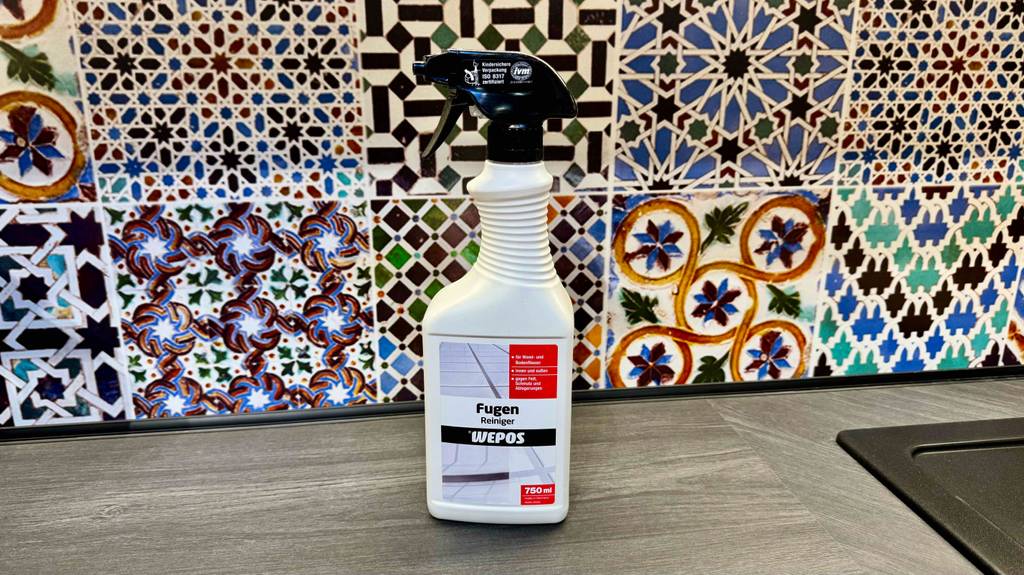 Fugenreiniger getestet: Die weiße Flasche mit schwarzem Sprühaufsatz steht vor einer gefliesten Oberfläche.