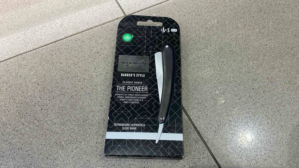 Ein getestetes Rasiermesser in Verpackung auf einem Fliesenboden.