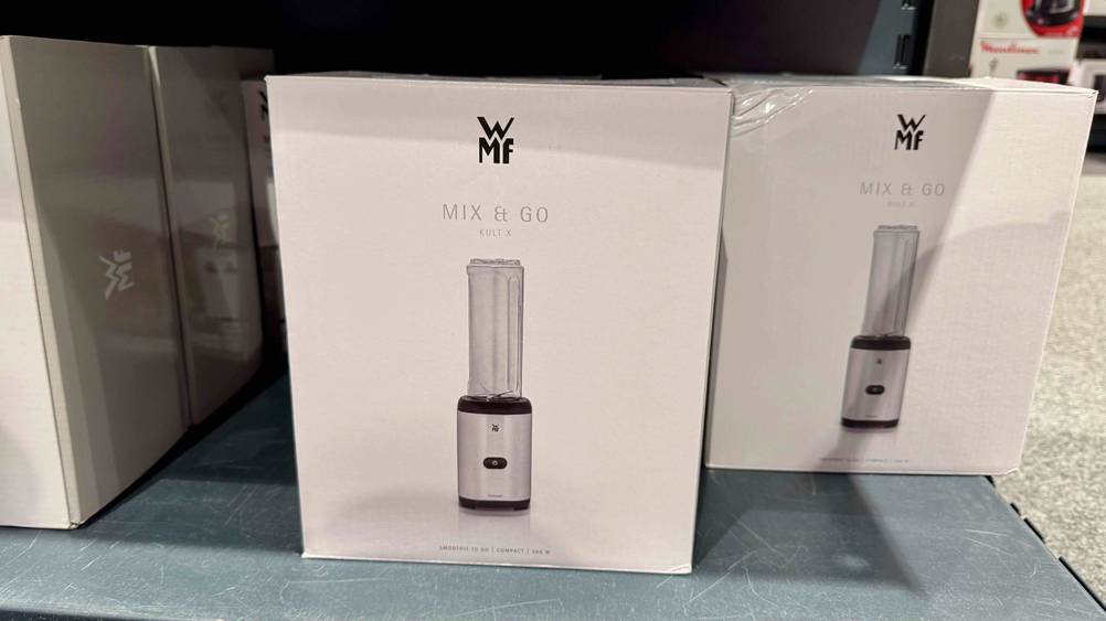 Mehrere Verpackungen des getesteten WMF-Mixers stehen in einem Regal.