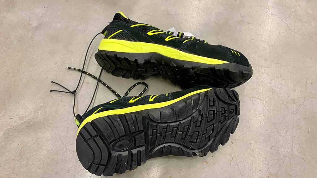 S1P-Sicherheitsschuhe für Damen getestet: Sohle eines Schuhs ersichtlich und eine Sicherheitsschuh von der Seite auf dem Boden platziert.