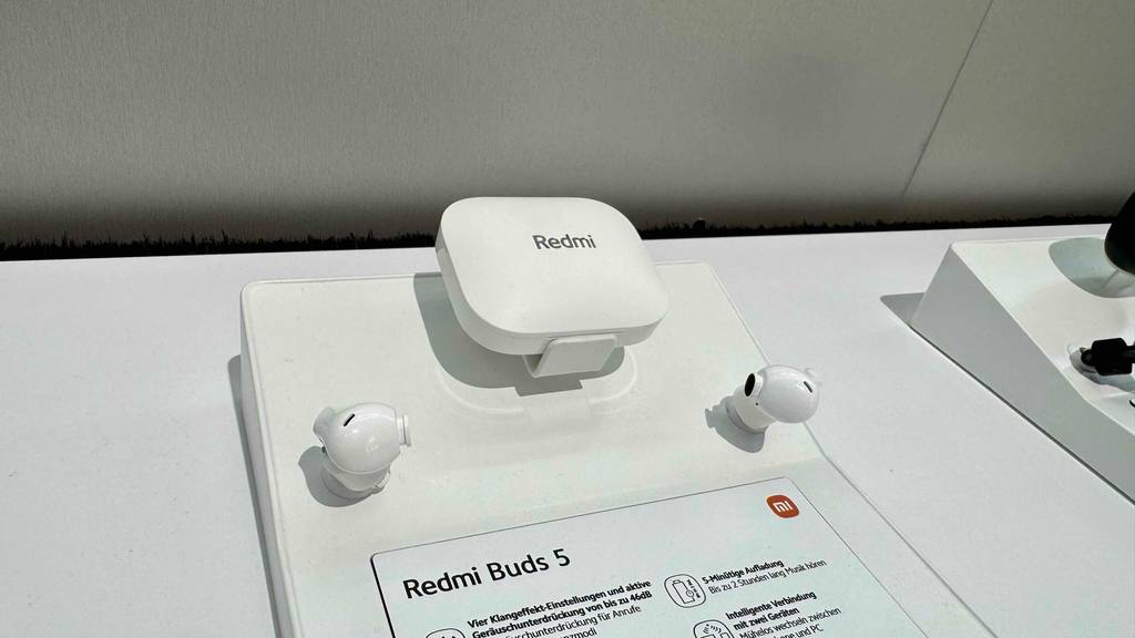 Xiaomi-Kopfhörer-Test: Ein Paar weiße In-Ear-Kopfhörer befinden sich auf einem Ausstellungstisch.