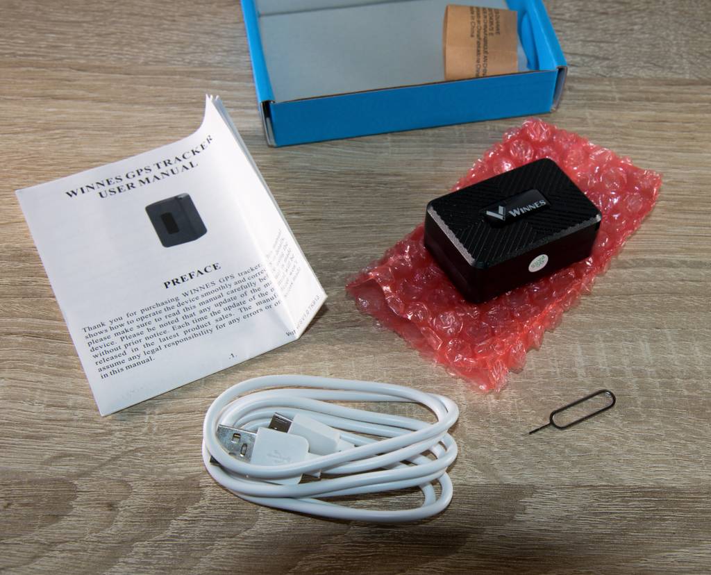 Verpackungsinhalt eines GPS Trackers für Kinder: Tracker, Kabel, Bedienunsanleitung etc.
