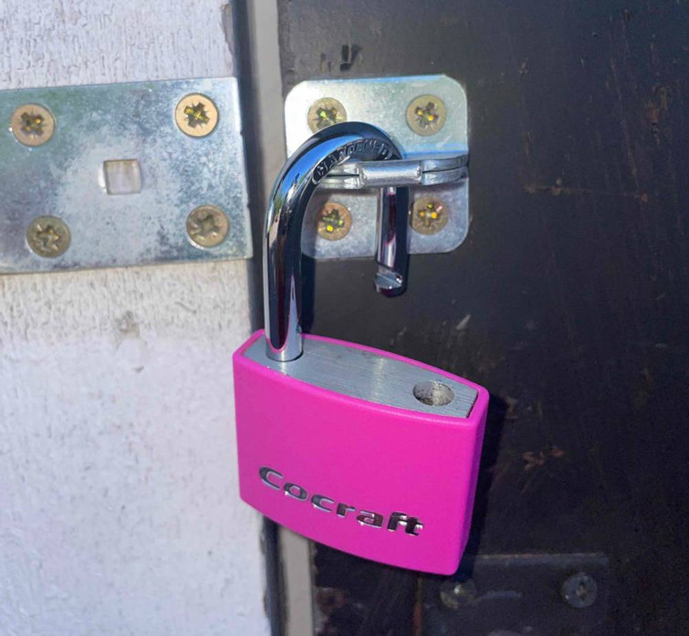 Vorhängeschloss-Test: ein Vorhängeschloss im geöffneten Zustand hängt an einer Türe.