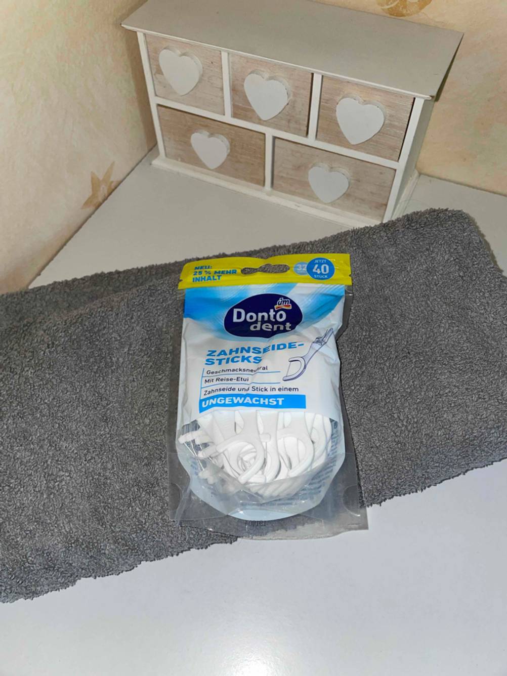 Zahnseide Packung auf Handtuch.
