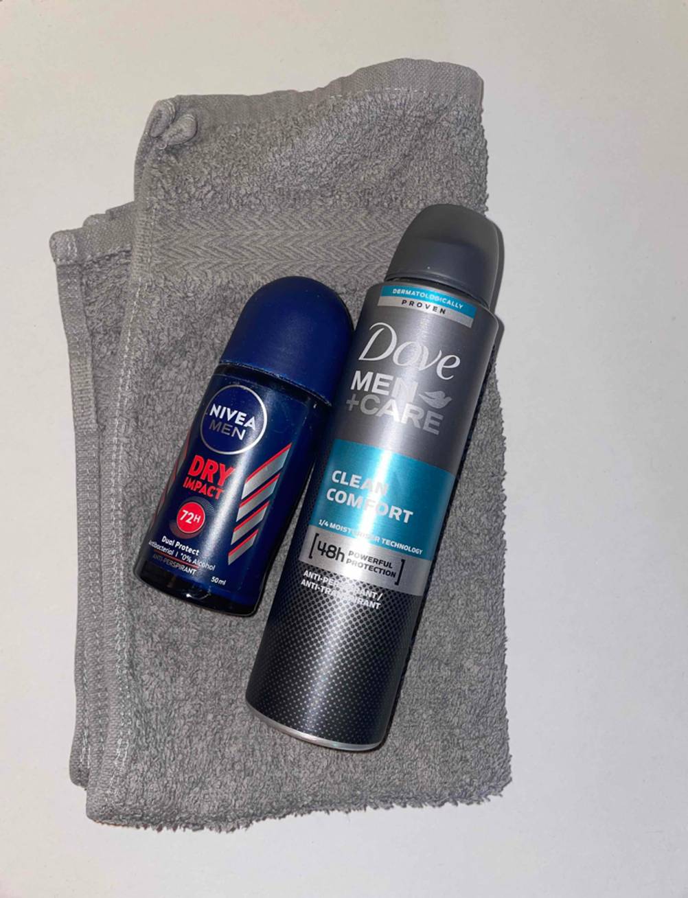 Deo-Roller und Deospray auf einem Handtuch.