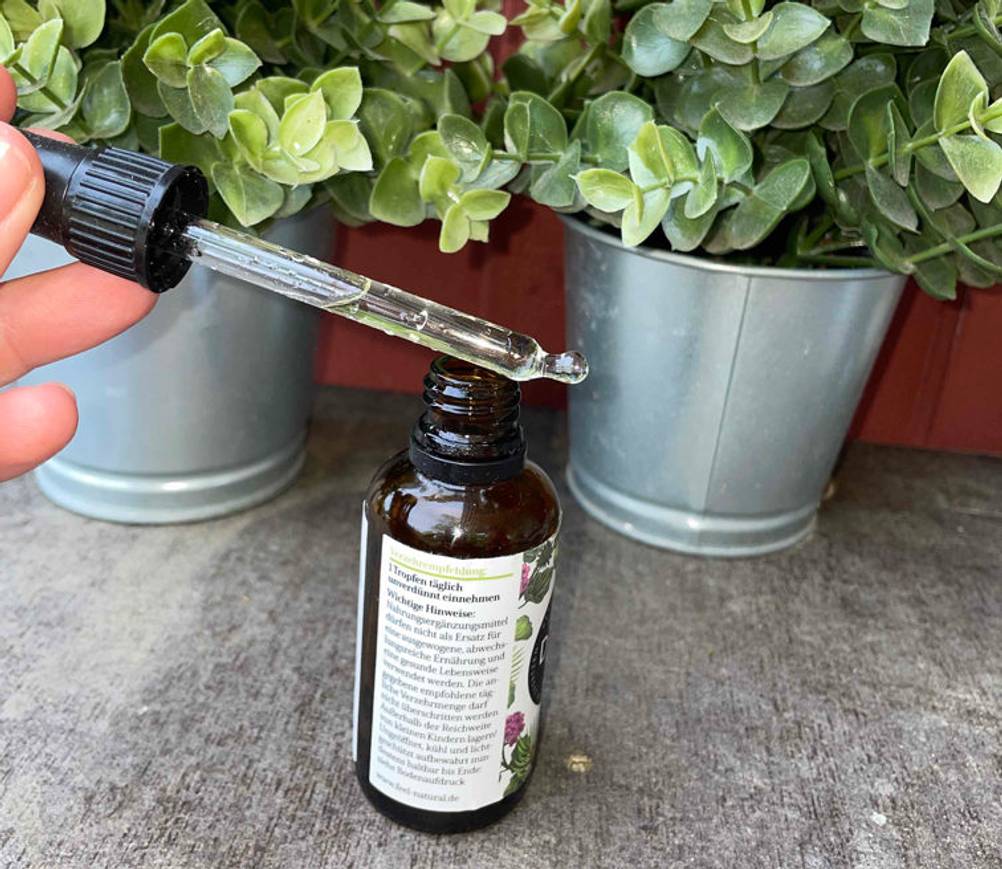 Die Pipette von getesteten Vitamin-d3-k2-Tropfen wird über das Fläschchen gehalten.