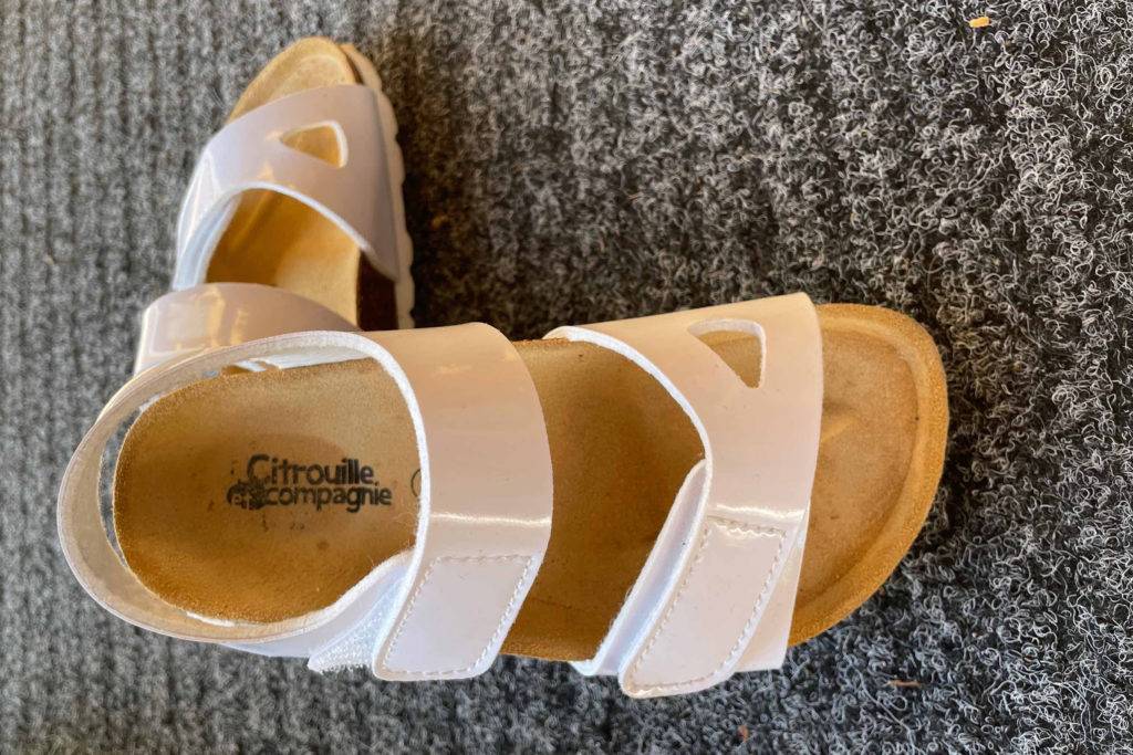 Weiße Kindersandalen.