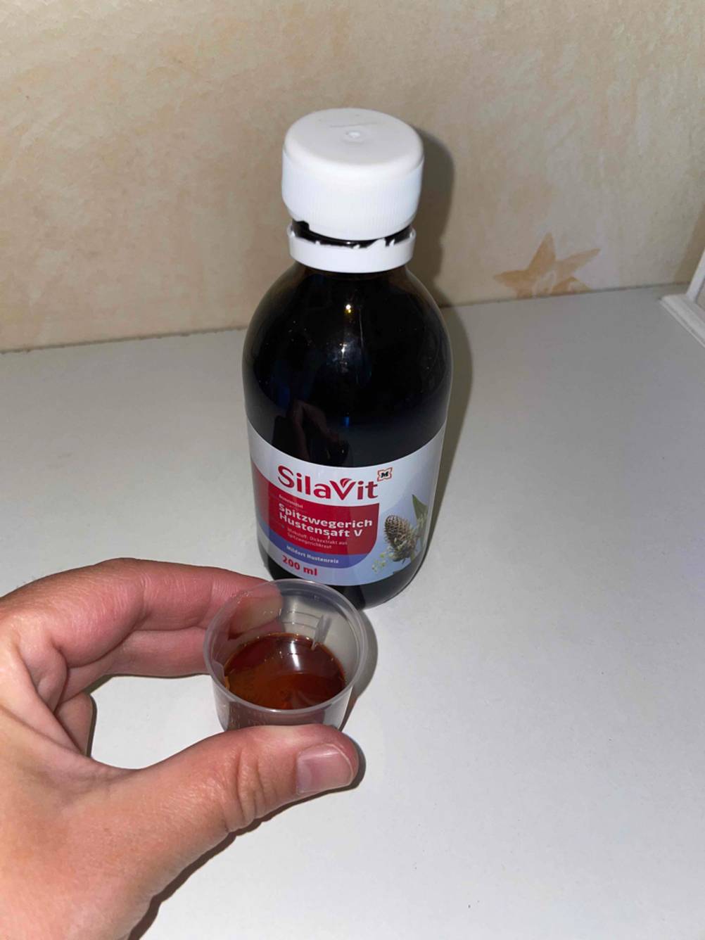 Saft in Kappe und Hustensaft stehend.