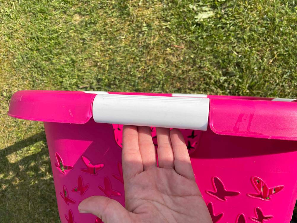 Wäschekorb getestet: der äußere Griff eines pinken Wäschekorbs im Fokus.