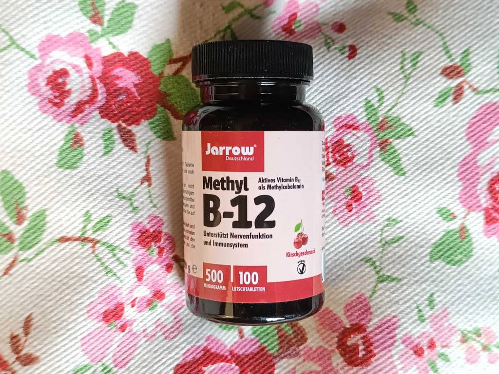 Vitamin-B12-Tabletten im Test: eine Packung Vitamin-B12-Tabletten liegend auf einem Stoff mit Blümchen darauf.