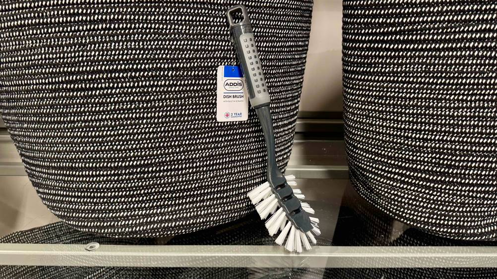Eine getestete Spülbürste ist an einem Korb angelehnt.