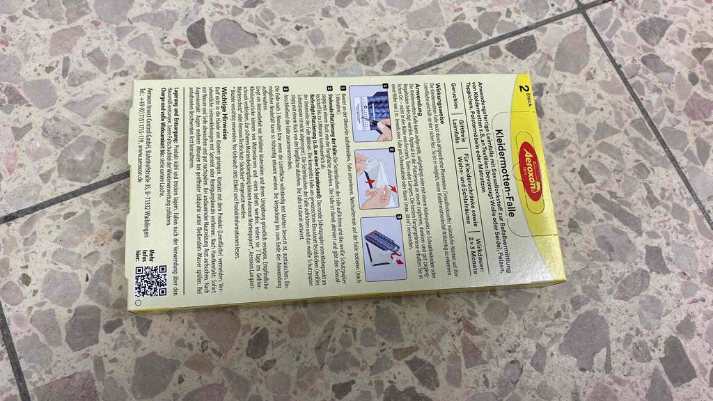 Kleidermottenfalle getestet: Eine Packung liegt mit ihrer Rückseite nach oben auf einem Fließenboden