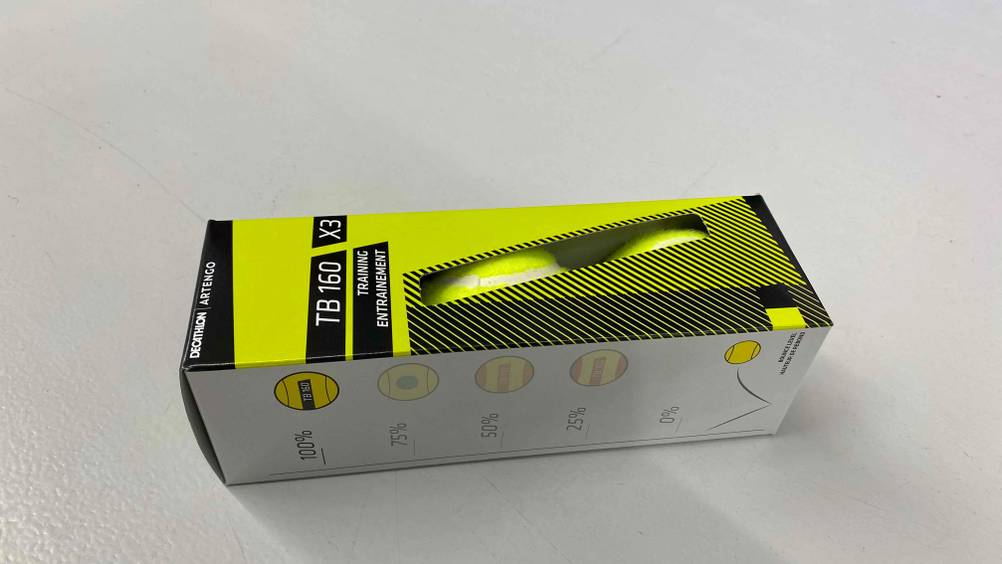 Eine Packung getesteter Tennisbälle liegt horizontal auf einer hellen Fläche