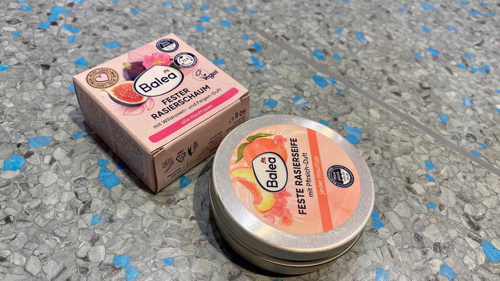 Rasierseife im Test: Eine Dose und Originalverpackung nebeneinander auf Fließenboden