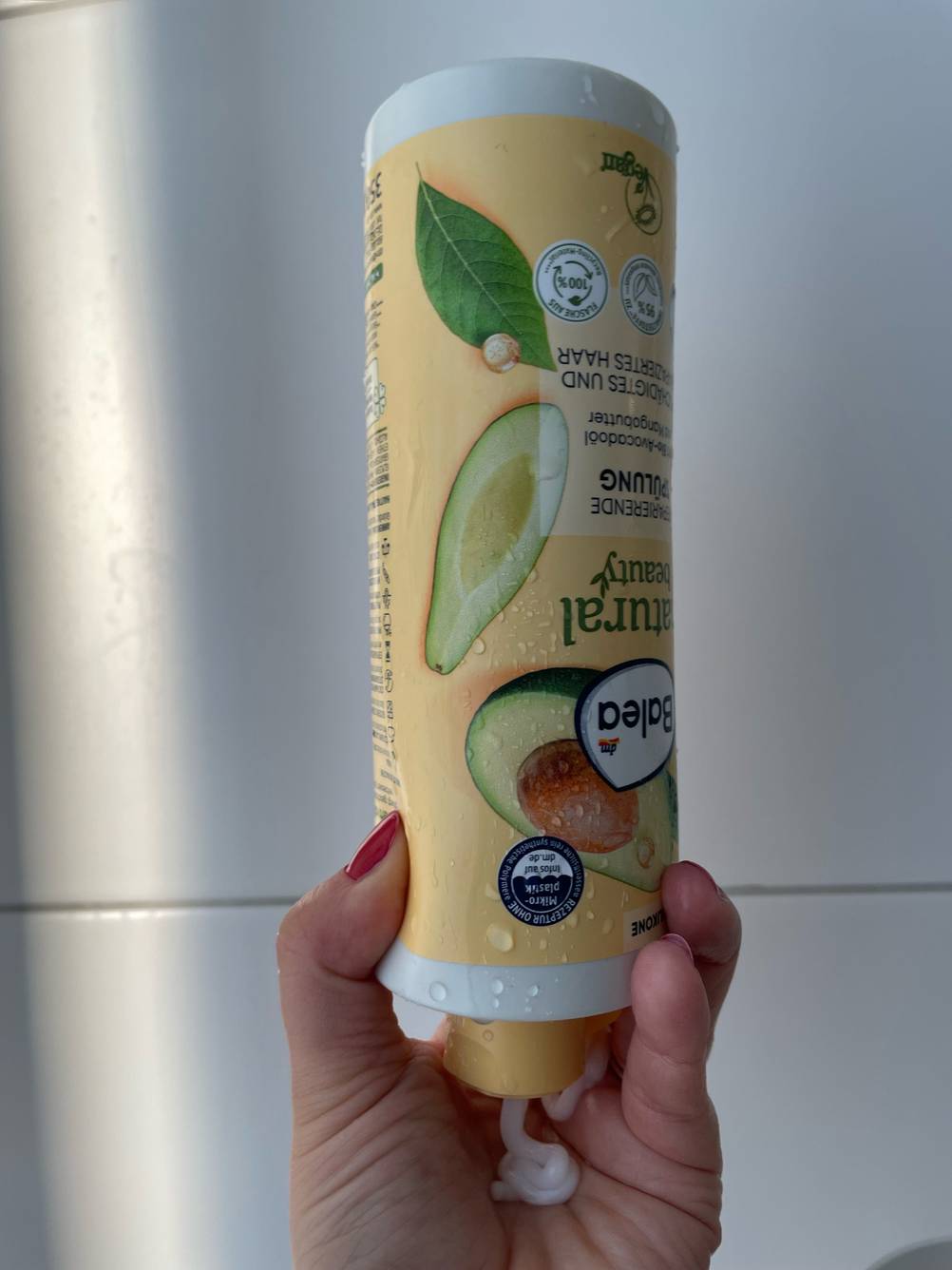 Balea-Haarbalsam im Test: Flasch wird über Kopf gehalten und Produkt fließ in die Hand.