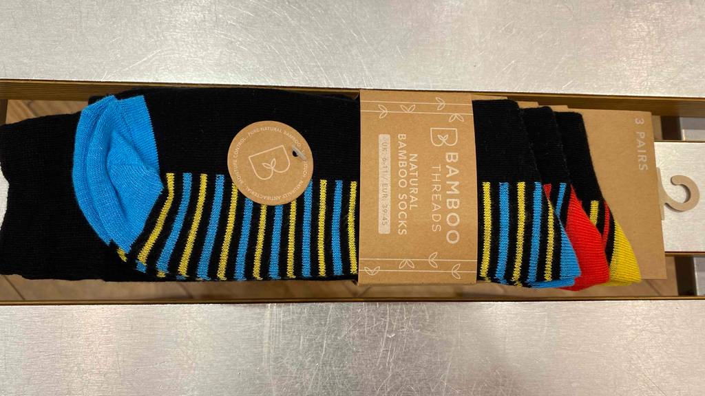 Bambussocken getestet: Socken in ihrer Originalverpackung liegen horizontal auf einer grauen Fläche.