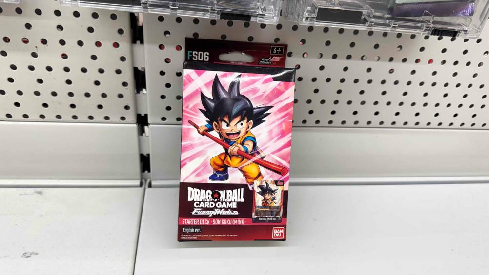 Die getesteten Dragon-Ball-Karten, die sich in der Verpackung befinden, sind an einem Regal angelehnt.