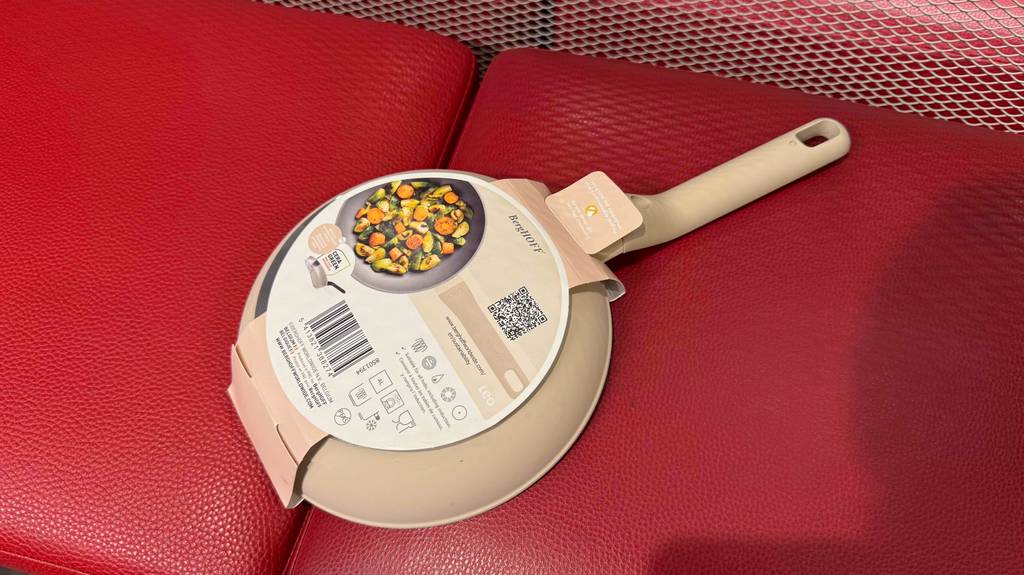 Rückseite der getesteten BergHOFF-Pfanne mit der Papiereinlage, worauf sich Pflegehinweise befinden.