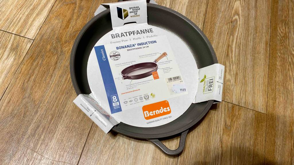 Berndes-Pfanne im Test: eine schwarze Berndes-Pfanne mit Papiereinlage darin auf einem Holzboden platziert.