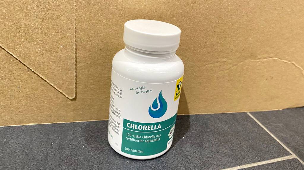 Chlorella getestet: Eine Dose steht vor einem Karton auf einer grauen Fläche