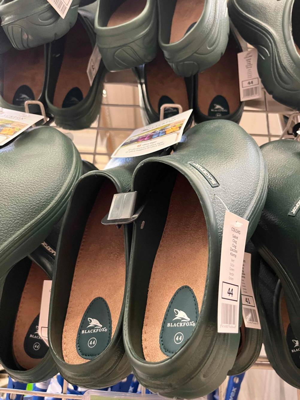 Gartenschuhe im Test: Mehrere Paare hängen an einem Gitter