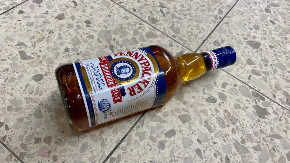Eine getestete Flasche Whisky liegt auf einem Fließenboden