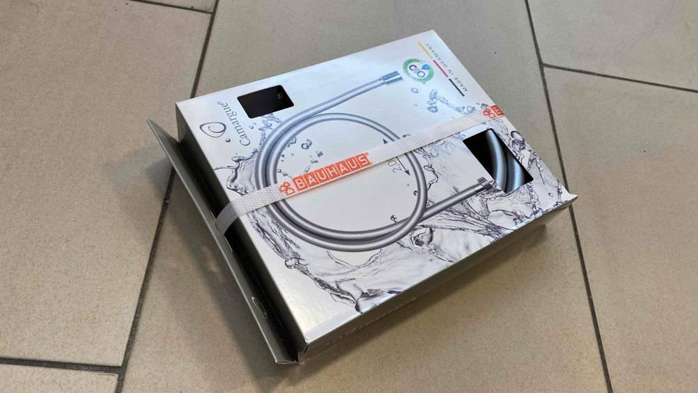 Brauseschlauch getestet: Eine Packung mit einem Brauseschlauch liegt auf einer Fließenoberfläche.