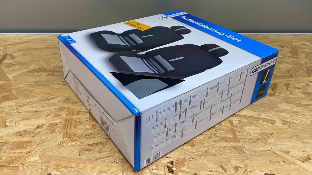 Autositzbezüge getestet: Eine Packung von schräg unten auf einer Holzfläche.