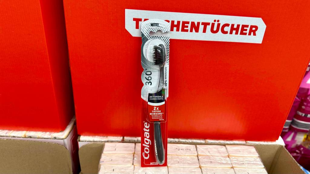 Aktivkohle-Zahnbürsten im Test: Ein Modell von Colgate steht vor einem roten Karton mit Taschentüchern.