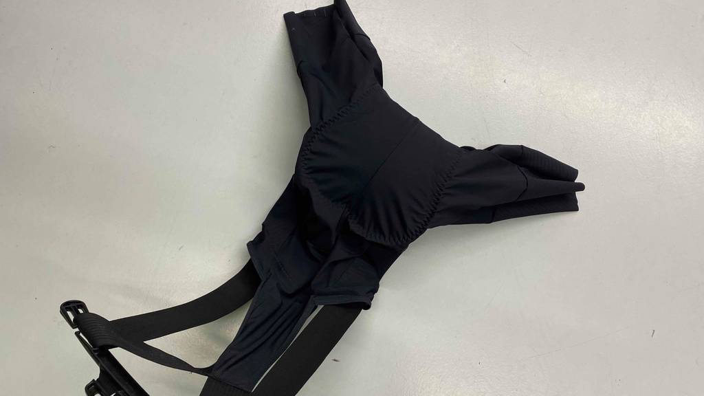 Eine getestete Fahrrad-Hose für Herren von hinten auf einer hellen Fläche liegend.