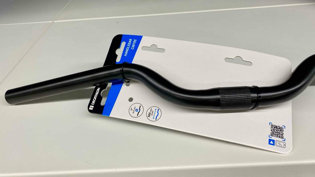 Fahrradlenker getestet: ein schwarzer Fahrradlenker in Nahaufnahme mit Kabelbinder an der Verpackung fixiert, worauf die Maße ersichtlich sind.